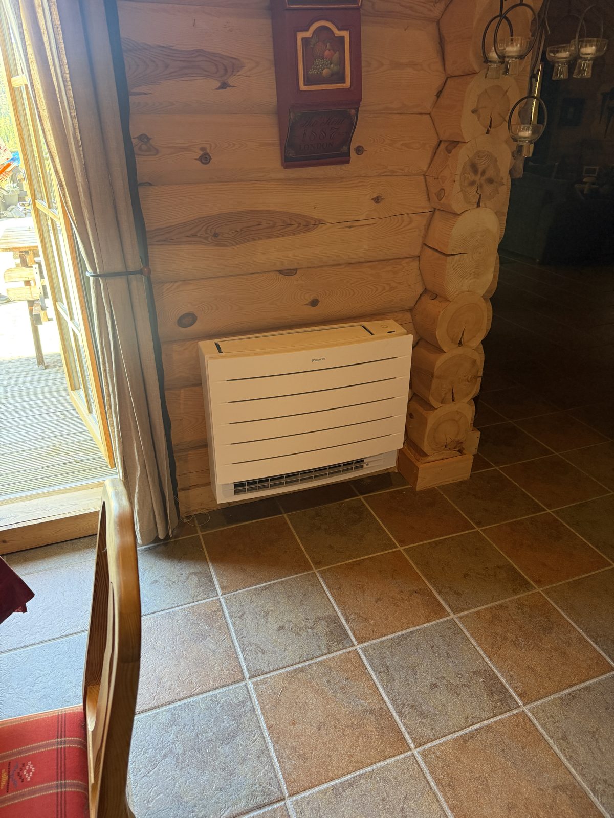 Daikin gulvmodell mot tømmervegg i hytte i Åseral