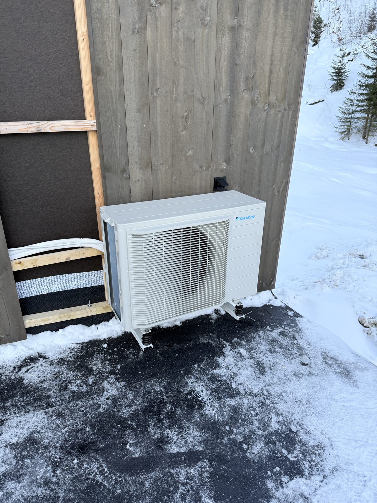 Daikin utedel på stativ ved hytte i snø på Torsland