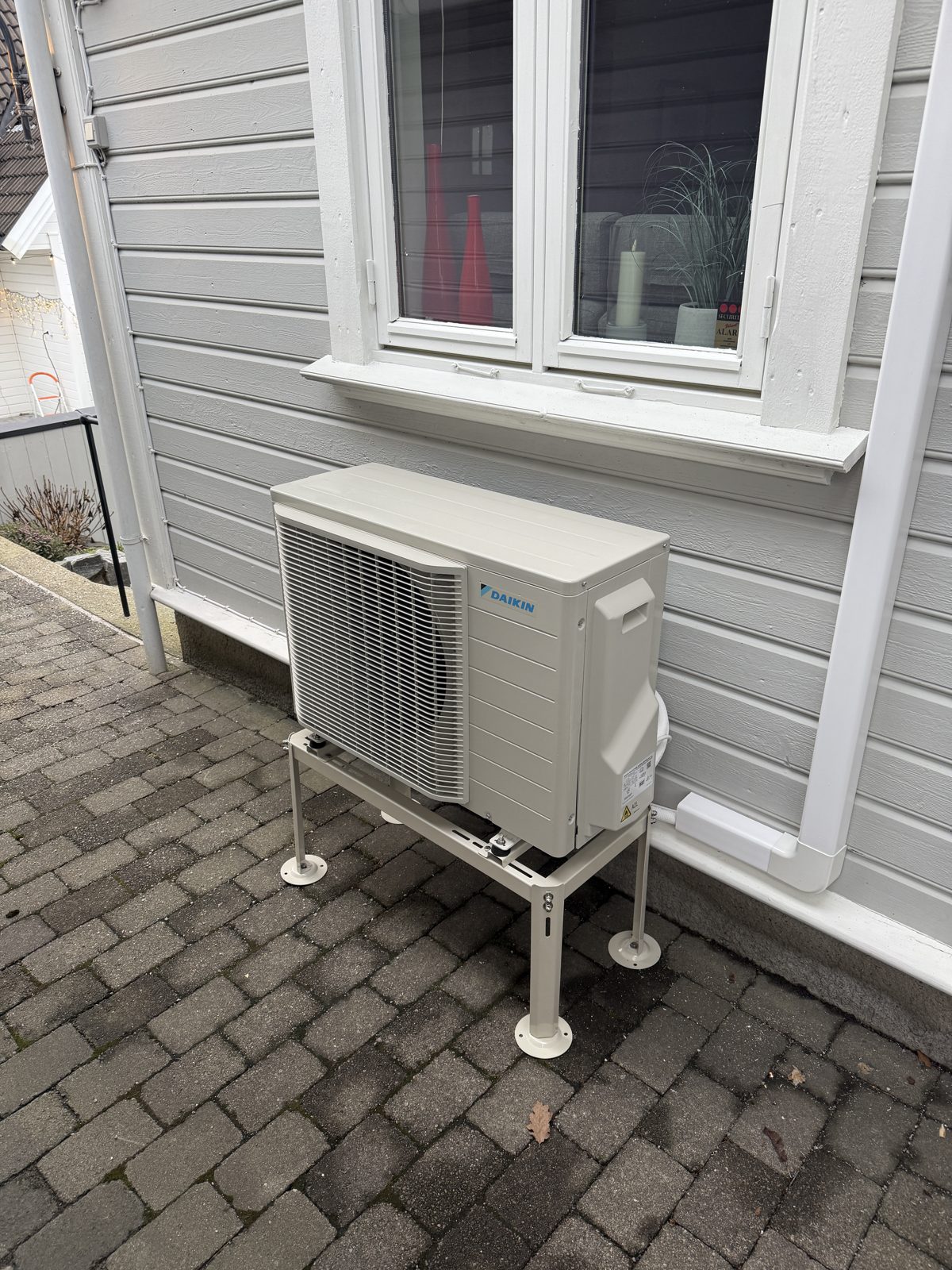 Daikin utedel på stativ ved hvitt hus i Kristiansand