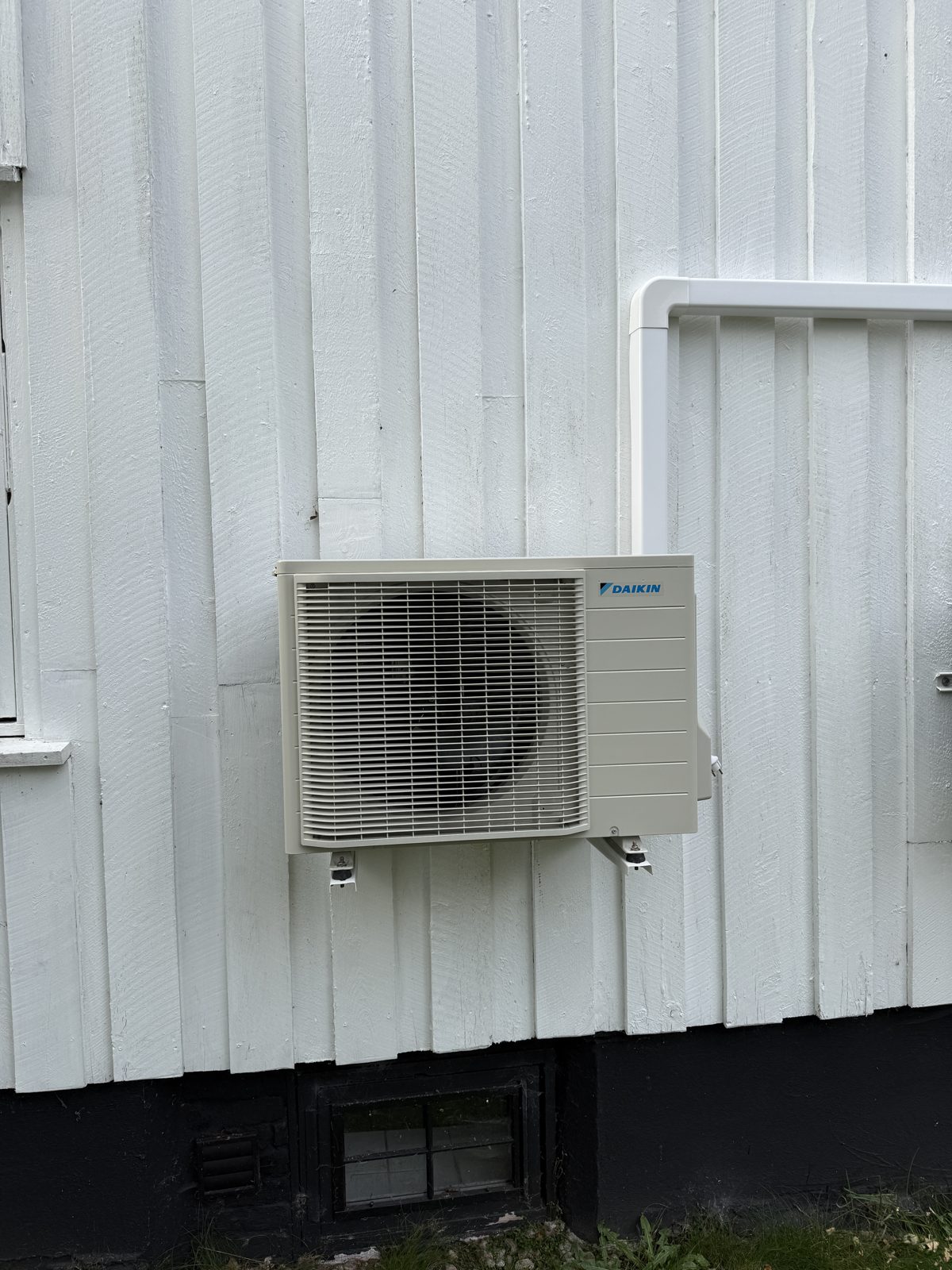 Daikin utedel på veggbrakett på hvit husvegg i Kristiansand